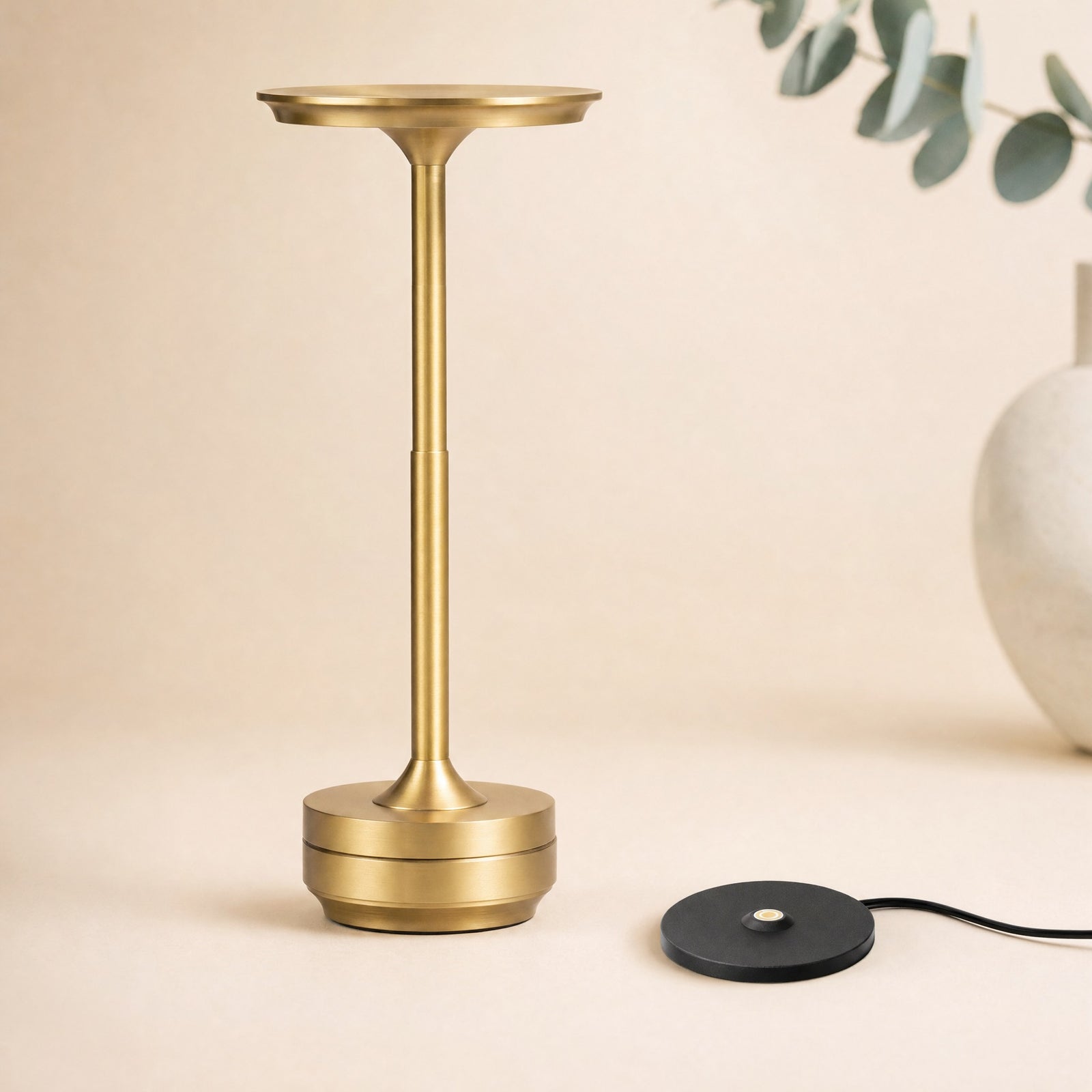 Gold Lumen Pro lamp and its individual contact charging base — studio product visualization
